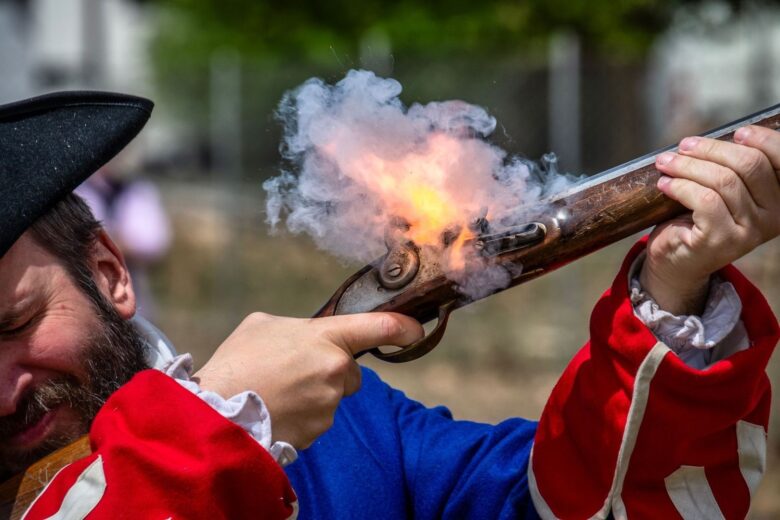 Historisk skytte affyrer en gevær med flintlåsmekanisme og røg