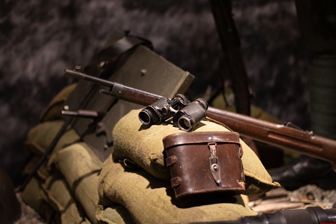 Historiske våben, kikkert og lædertaske på sandsække
