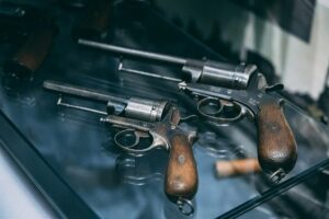 To antikke pistoler med træskæfter udstillet i en glasskabine