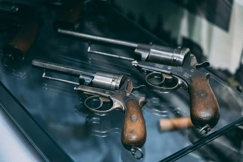 To antikke pistoler med træskæfter udstillet i en glasskabine